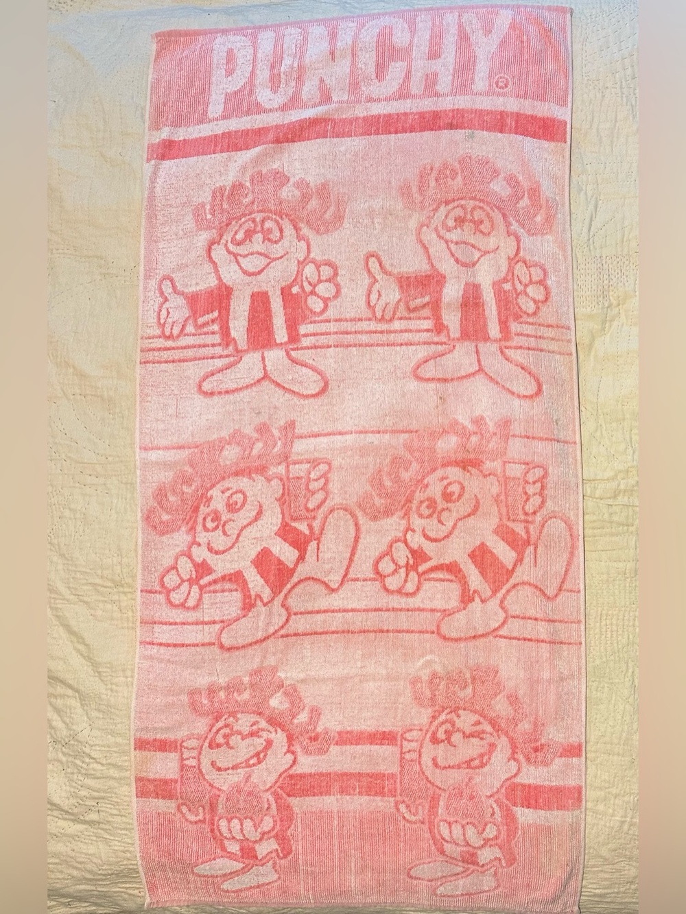 Pink and white 70s beach towel featuring Punchy, the Hawaiian Punch Mascot